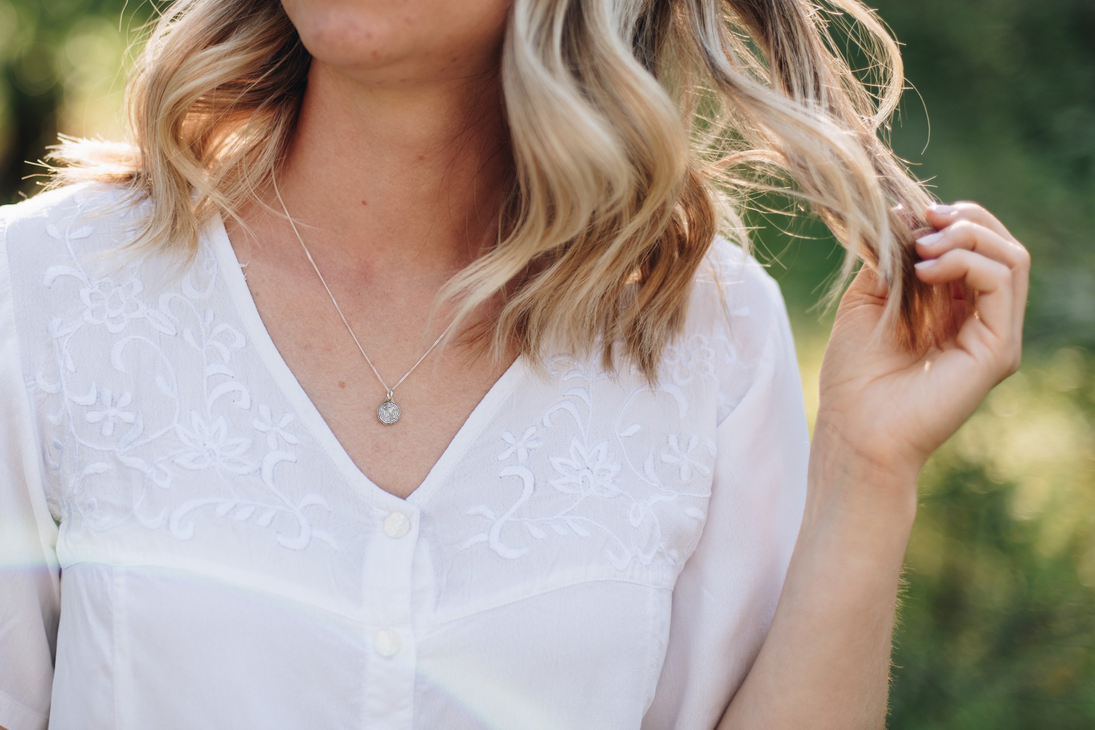 dainty tree slice tree necklace on a woman with blonde hair