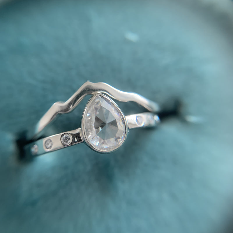 White gold mountain ring with Mount Baker with a pear rose cut moissanite engagement ring.