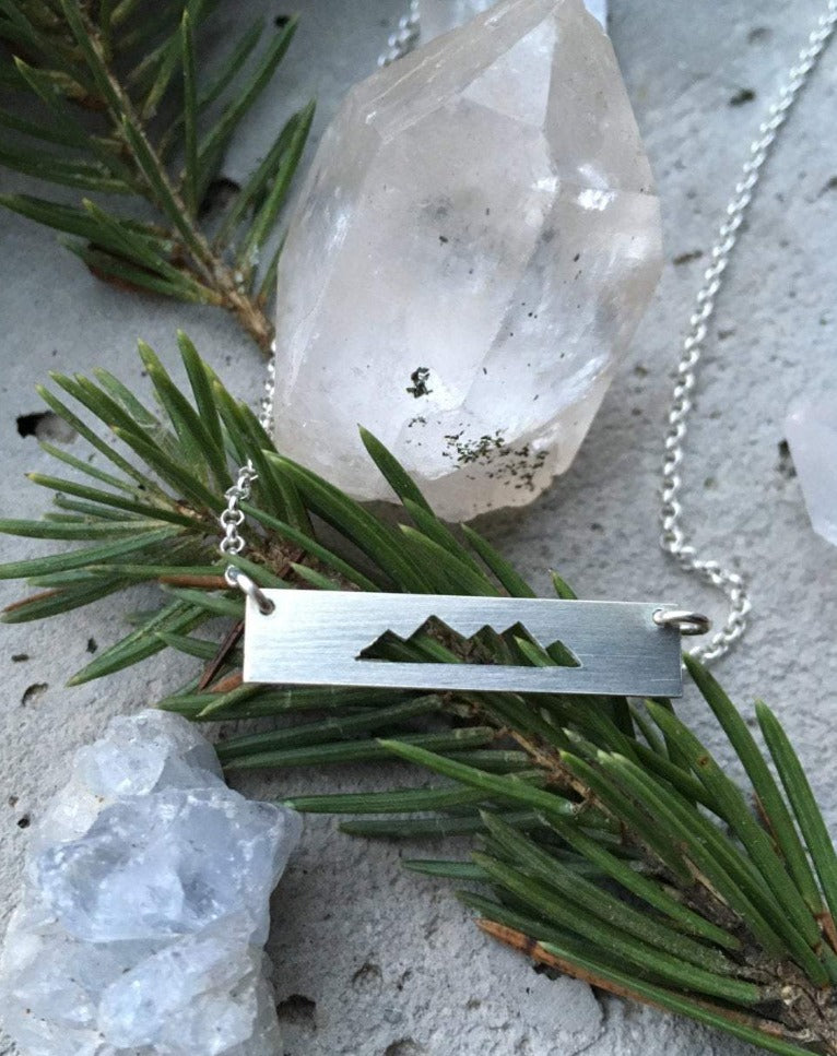 Silver bar necklace with mountain cut out on chain.