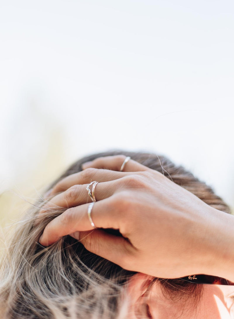 Mountain ring on a hand running through her hair.