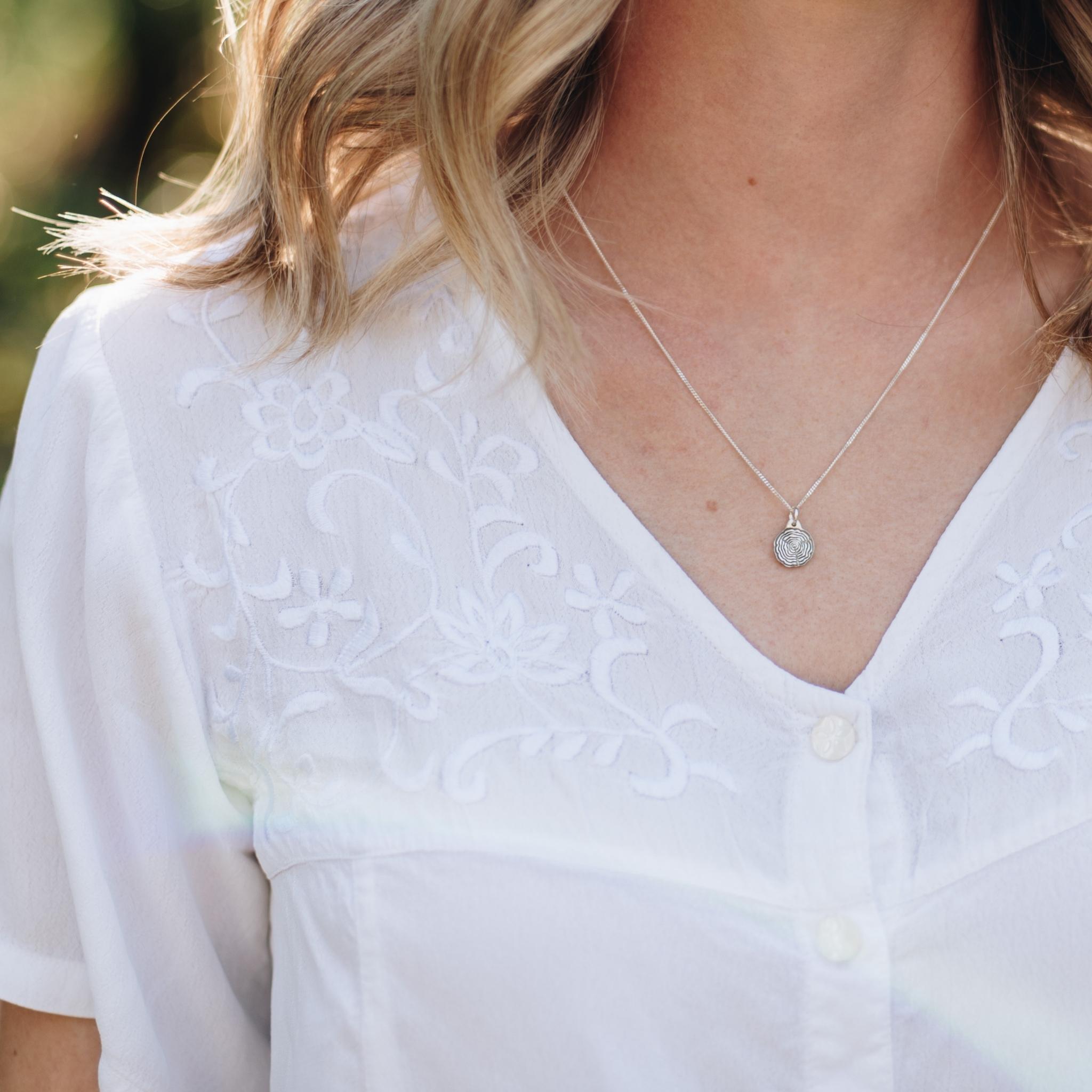 dainty tree slice tree necklace on a woman with blonde hair