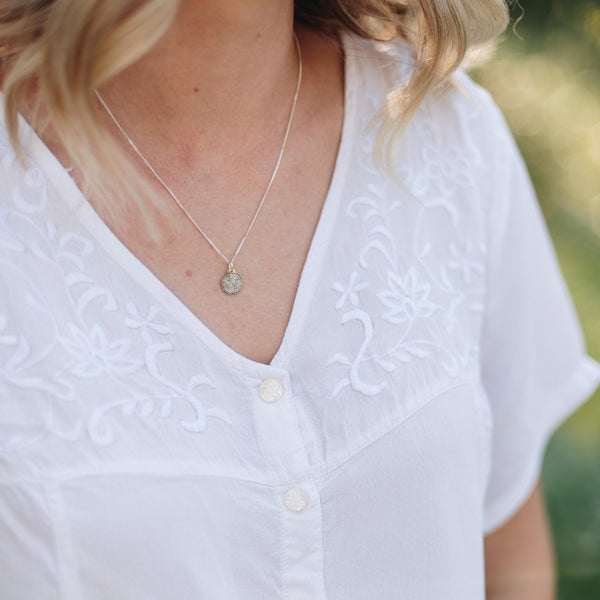 dainty tree slice tree necklace on a woman with blonde hair