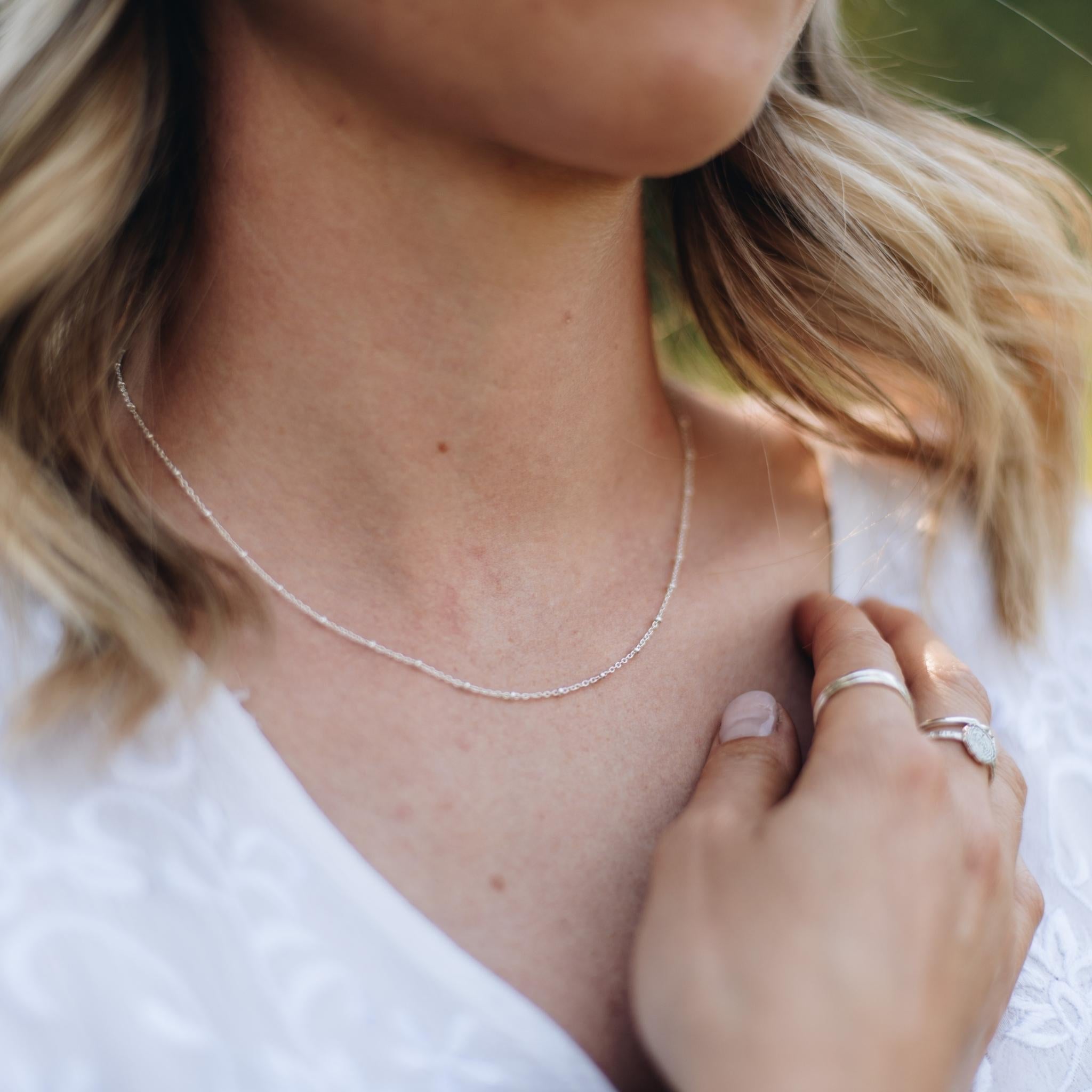 Delicate Silver beaded chain on a women with blonde hair